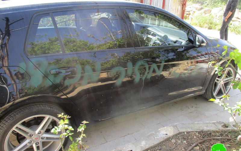 Israeli colonists write racist graffiti and slash cars’ tires in Qalqiliya