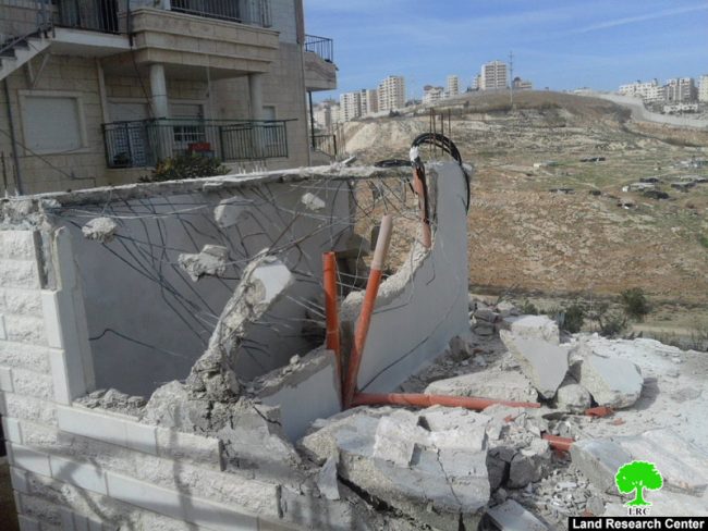مواطن يقوم مجبراً على هدم مسكنه ذاتياً تنفيذاً لقرار بلدية الاحتلال في قرية العيسوية